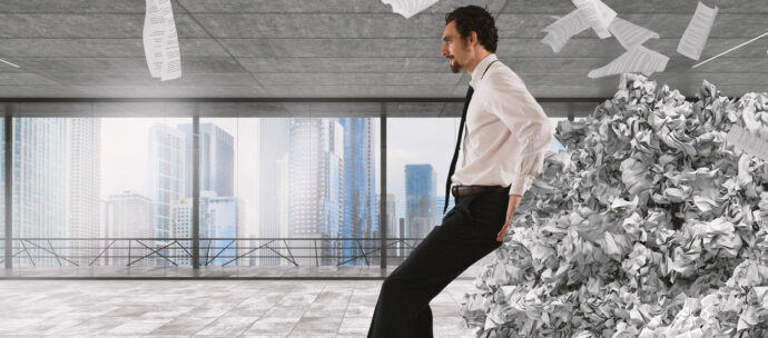 businessman-pushing-with-fatigue-big-pile-paperwork